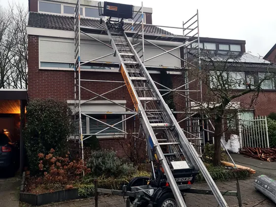 Steiger en ladderlift tegen de gevel van een woning